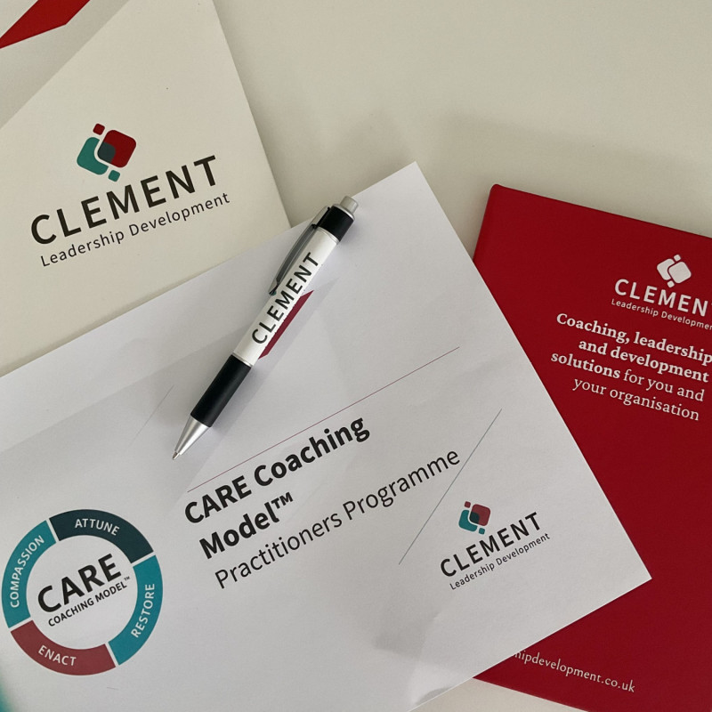 A flat lay featuring Clement Leadership Development materials, including a branded folder, pen, and programme document titled “CARE Coaching Model™ Practitioners Programme.” The CARE Coaching Model circular logo appears prominently, representing professio